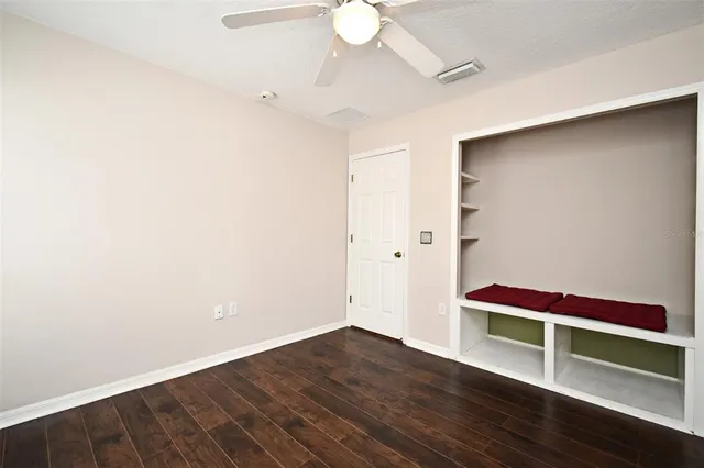an empty room with wooden floor and white walls