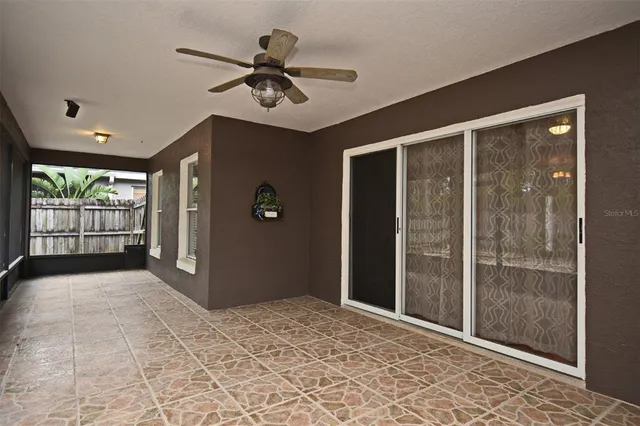 a view of a hallway with a chandelier fan and windows