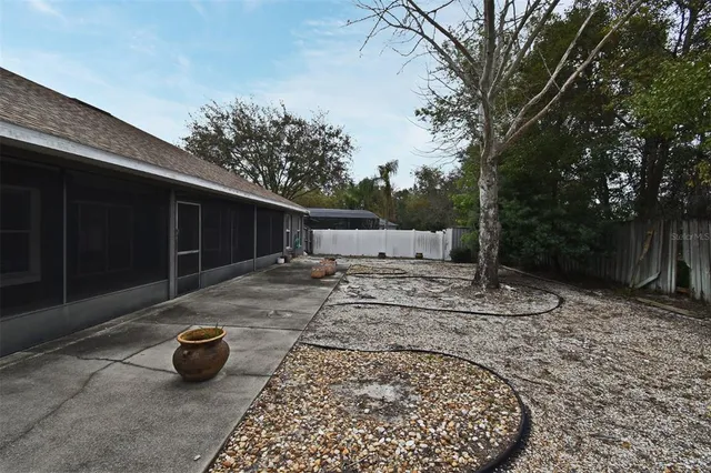 a view of a backyard with table and chairs plants and trees