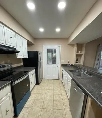 a large kitchen with stainless steel appliances granite countertop a stove sink and cabinets