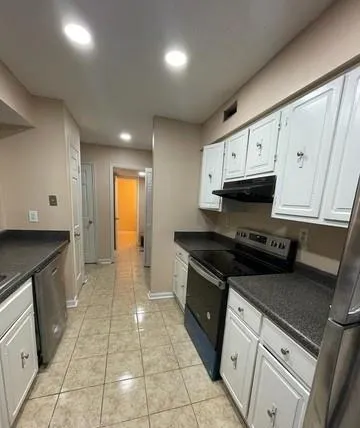 a kitchen with granite countertop a stove a sink and a cabinets