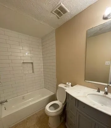 a bathroom with a granite countertop toilet a sink and bathtub