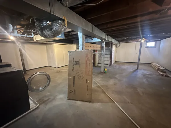 a room with water heater and wooden cabinets