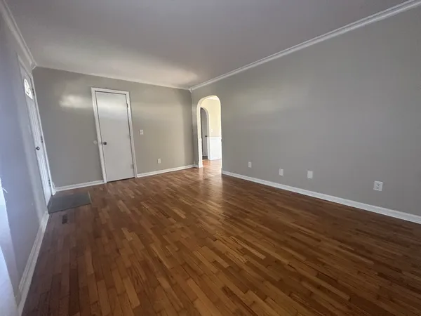 a view of a room with wooden floor and window