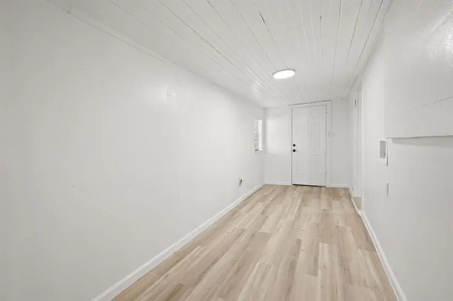 a view of a room with wooden floor and white walls