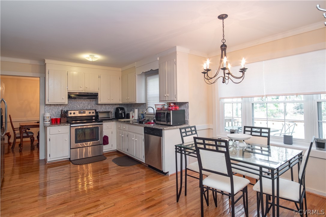 12210 Robious Road Midlothian, VA 23113 - Photo 4 of 30 a kitchen with stainless steel appliances kitchen island granite countertop a stove top oven a sink a dining table and chairs with wooden floor