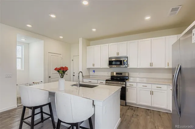 a kitchen with white cabinets and stainless steel appliances