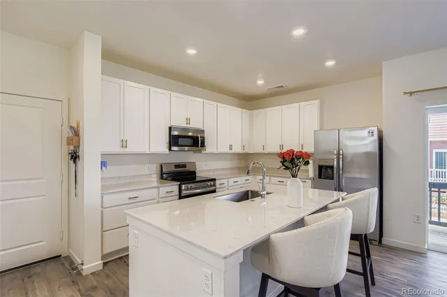 a kitchen with white cabinets and stainless steel appliances