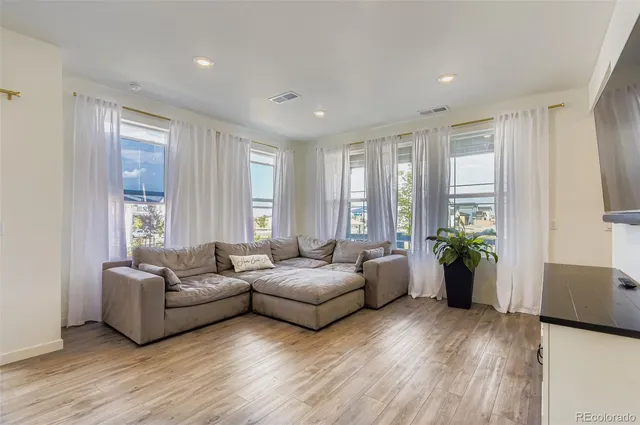 a living room with furniture and wooden floor