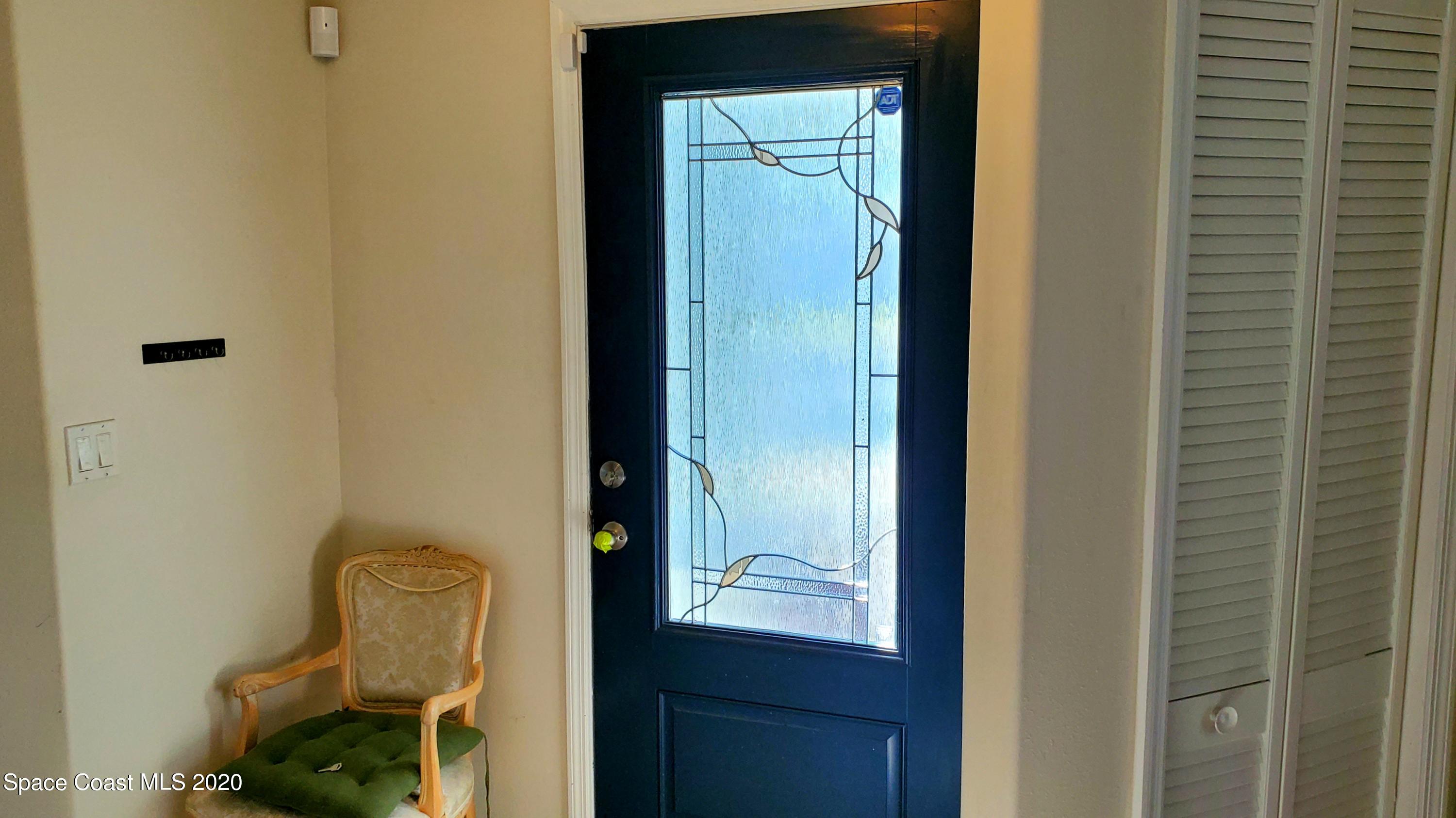 920 Grove Avenue Cocoa, FL 32922 - Photo 2 of 13 a room with mirror and a wooden door