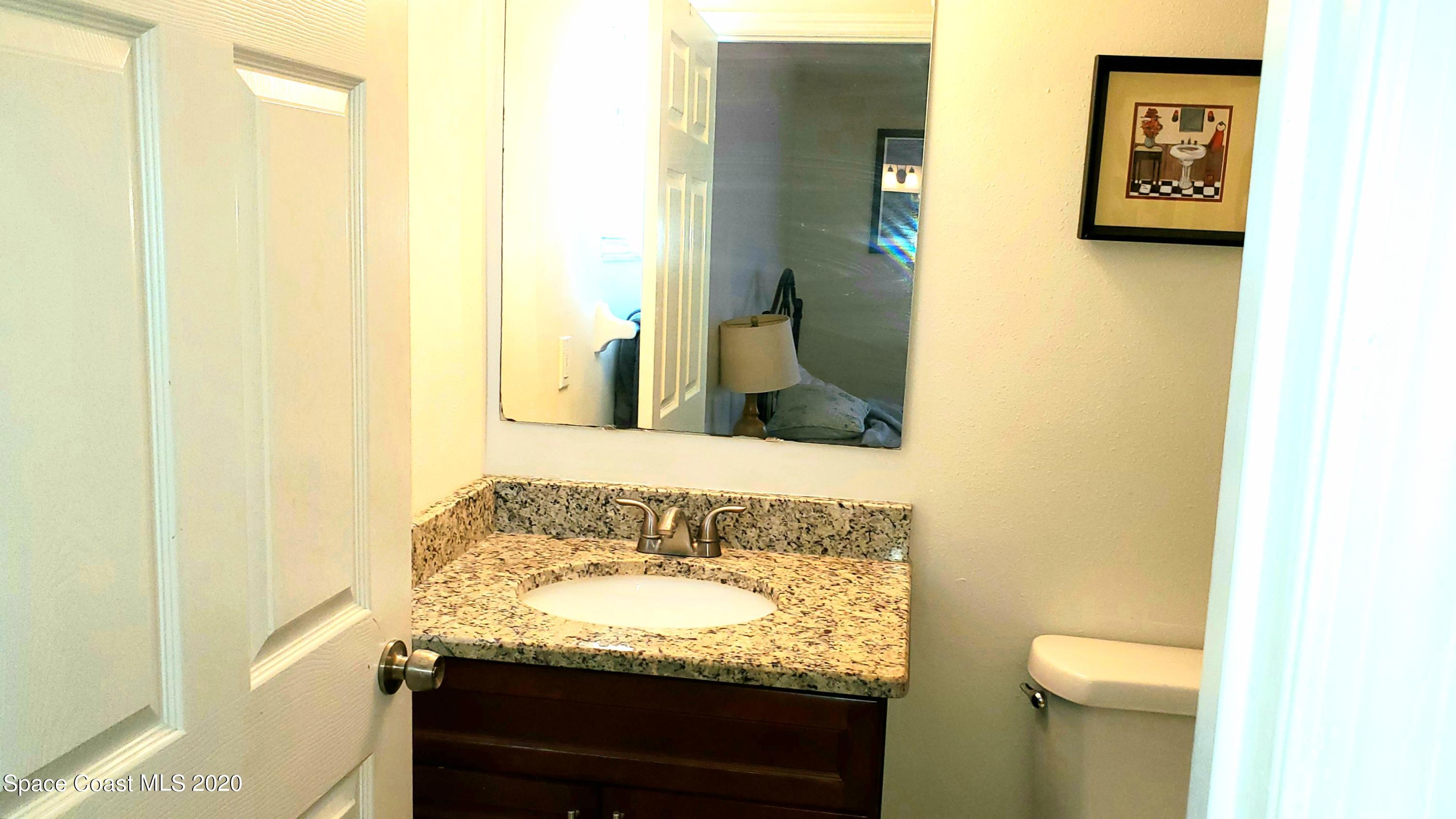 920 Grove Avenue Cocoa, FL 32922 - Photo 11 of 13 a bathroom with a granite countertop sink and a mirror