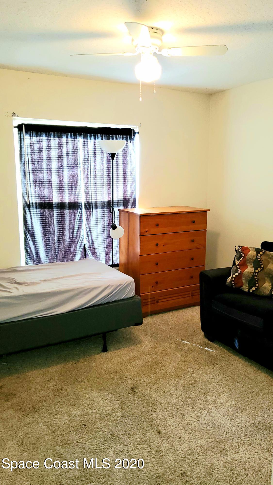 920 Grove Avenue Cocoa, FL 32922 - Photo 3 of 13 a bedroom with a bed and window