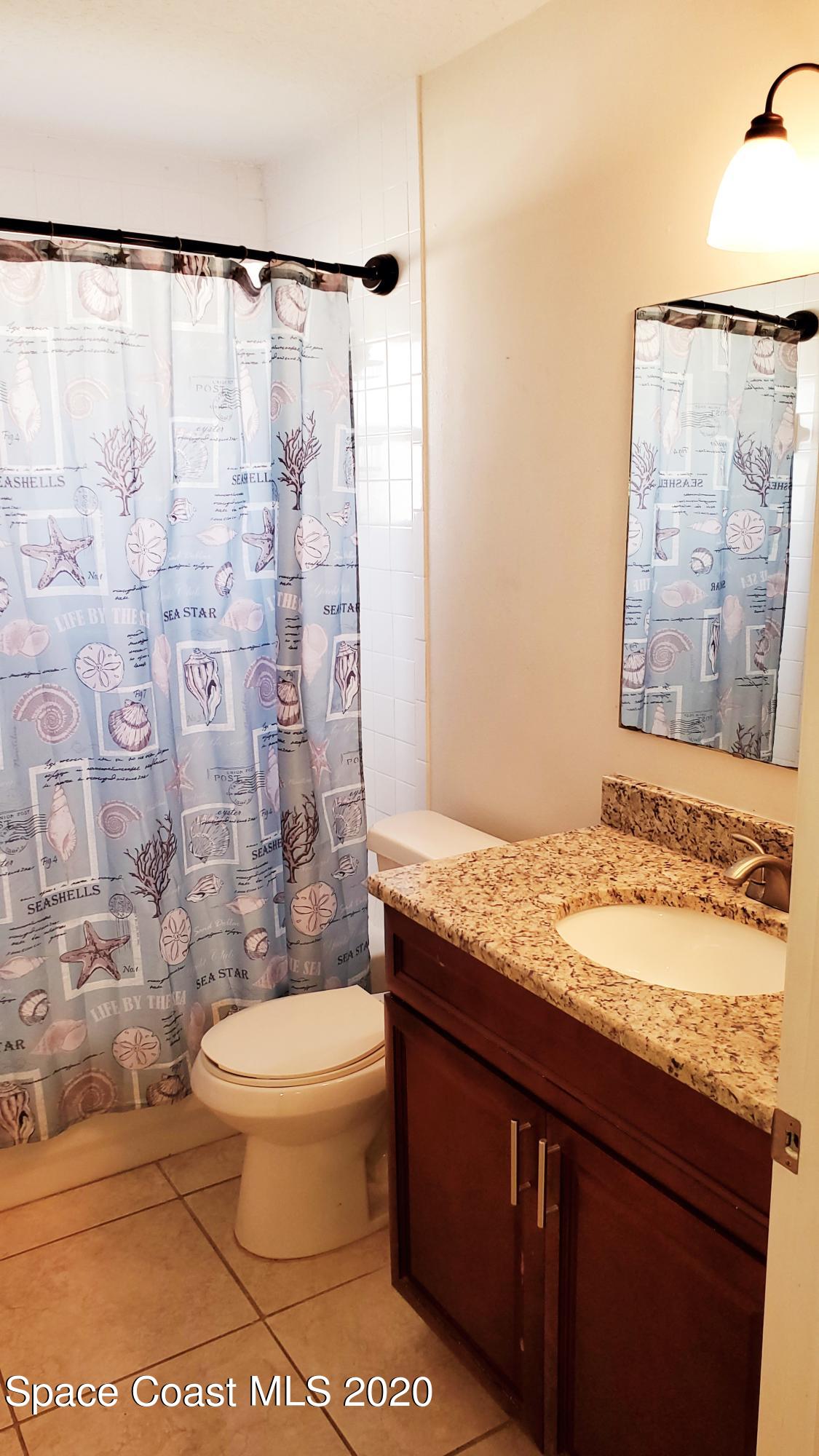 920 Grove Avenue Cocoa, FL 32922 - Photo 4 of 13 a bathroom with a granite countertop sink toilet and shower