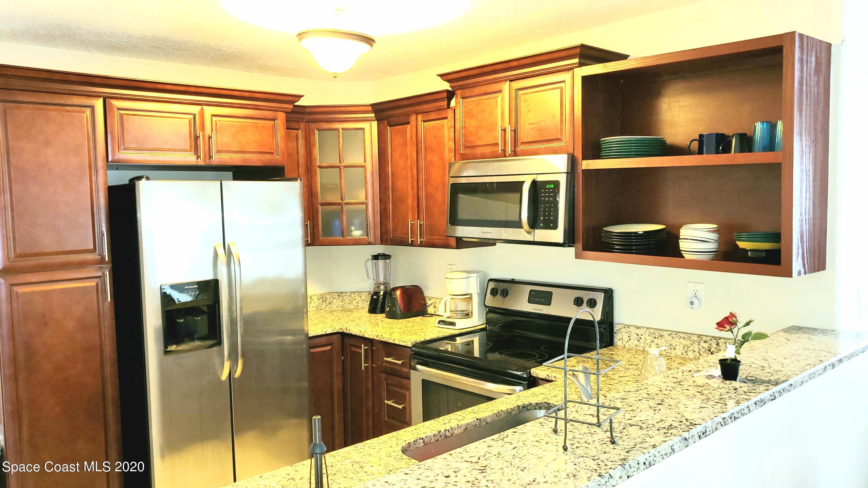 920 Grove Avenue Cocoa, FL 32922 - Photo 7 of 13 a kitchen with stainless steel appliances granite countertop a refrigerator and a sink