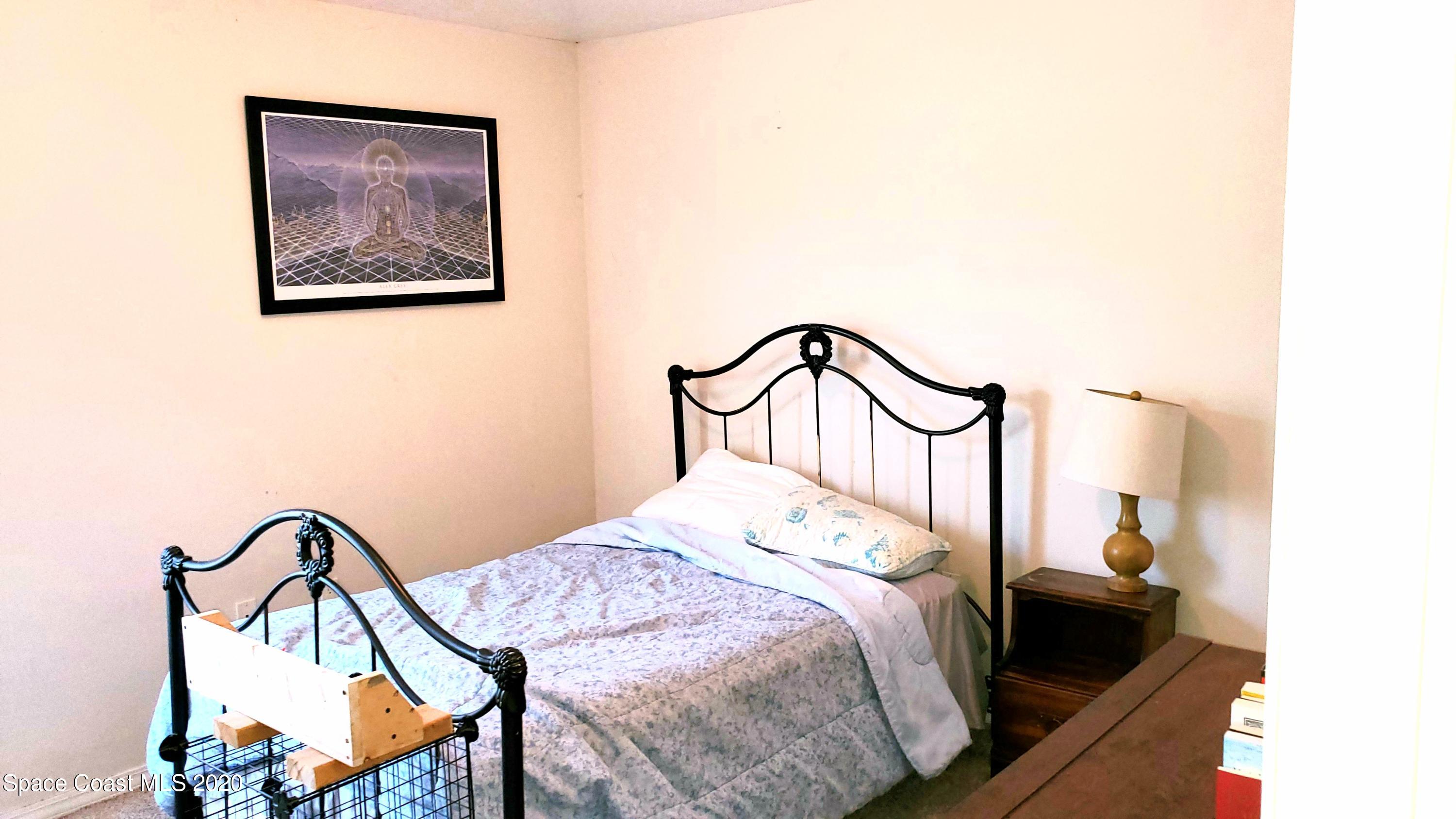 920 Grove Avenue Cocoa, FL 32922 - Photo 10 of 13 a bedroom with a bed and a painting on the wall