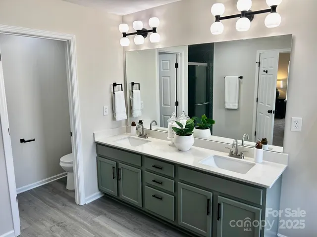 a bathroom with a double vanity sink a toilet and a mirror