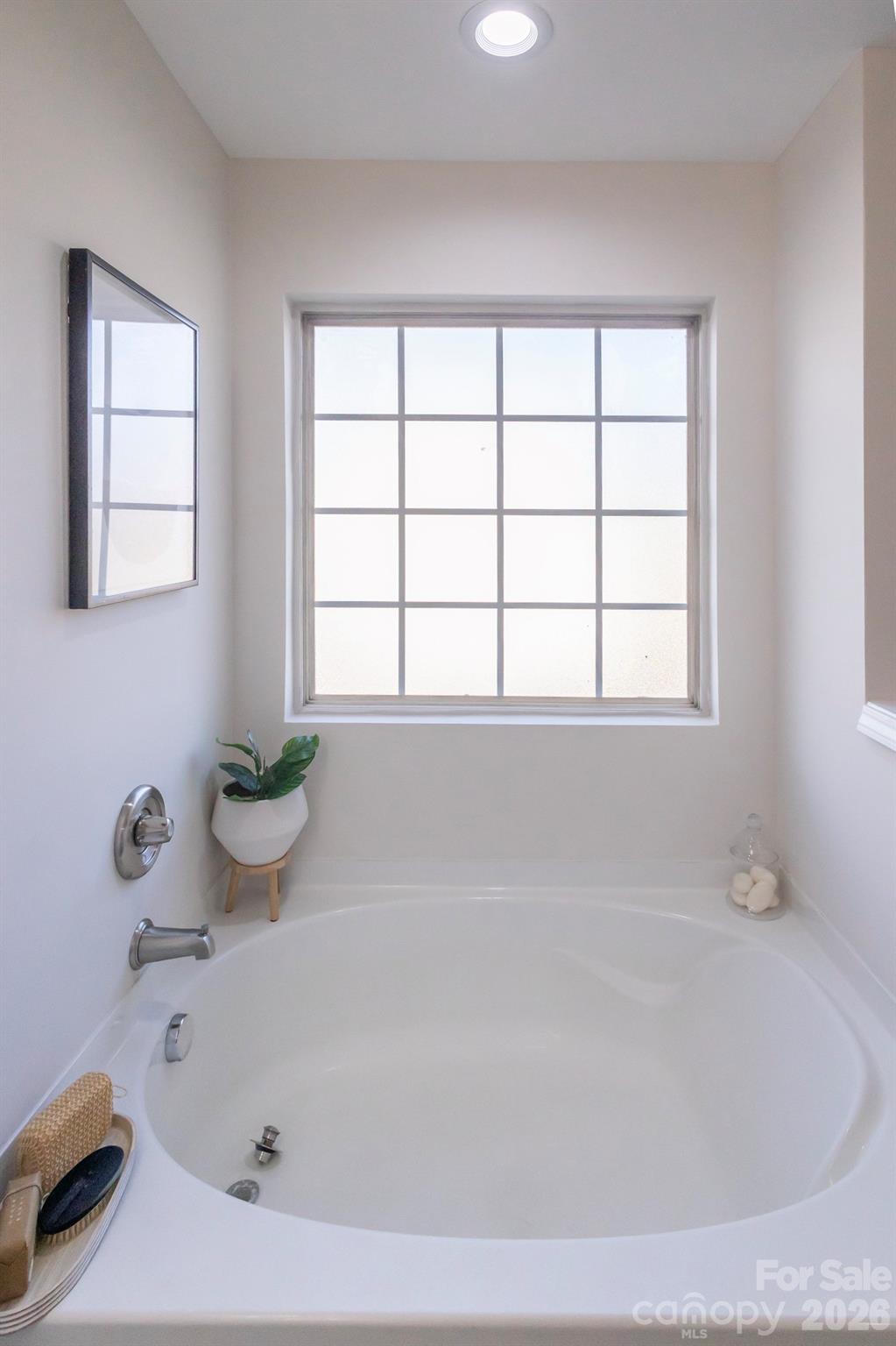 10631 Atkins Ridge Drive Charlotte, NC 28213 - Photo 20 of 38 a bathroom with a bathtub and window