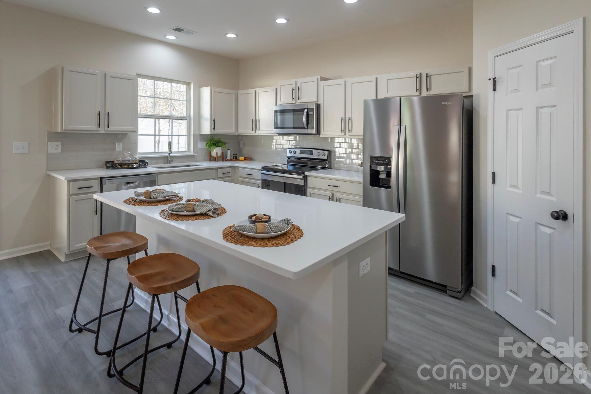 10631 Atkins Ridge Drive Charlotte, NC 28213 - Photo 2 of 38 a kitchen with stainless steel appliances a table chairs and a refrigerator