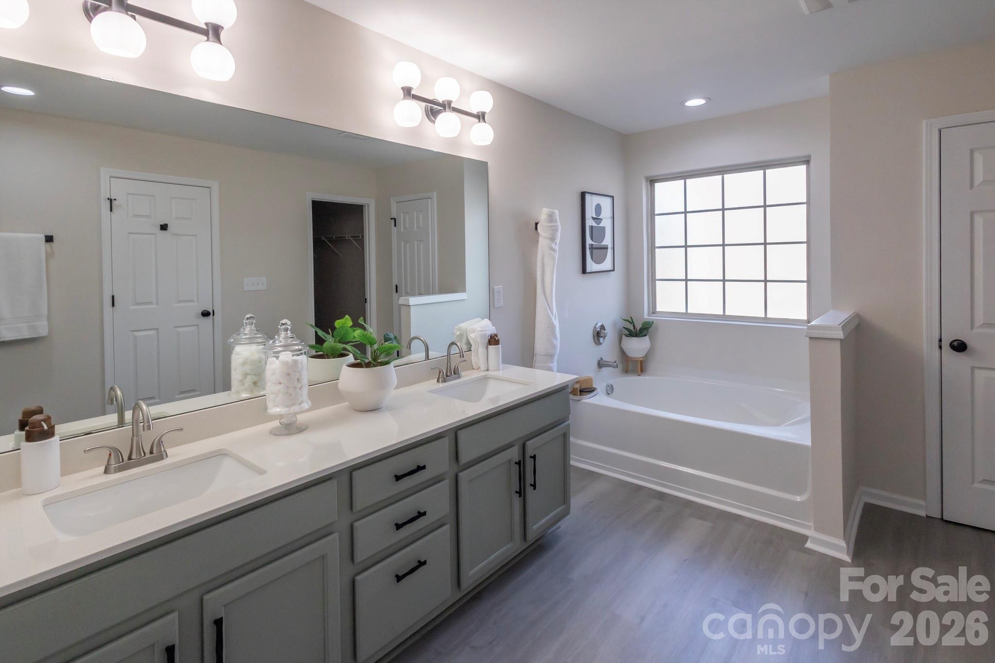 10631 Atkins Ridge Drive Charlotte, NC 28213 - Photo 21 of 38 a bathroom with a tub double sink window and mirror