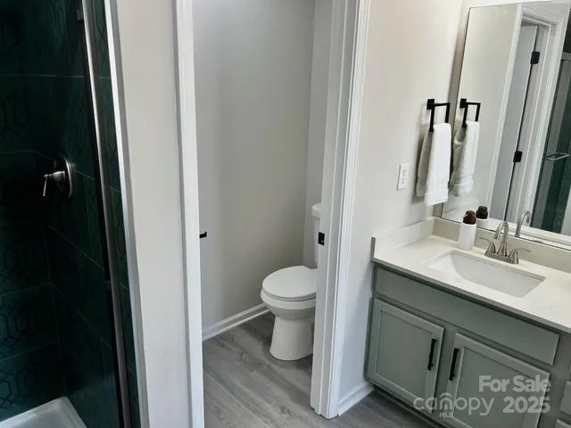 a bathroom with a granite countertop sink toilet and shower