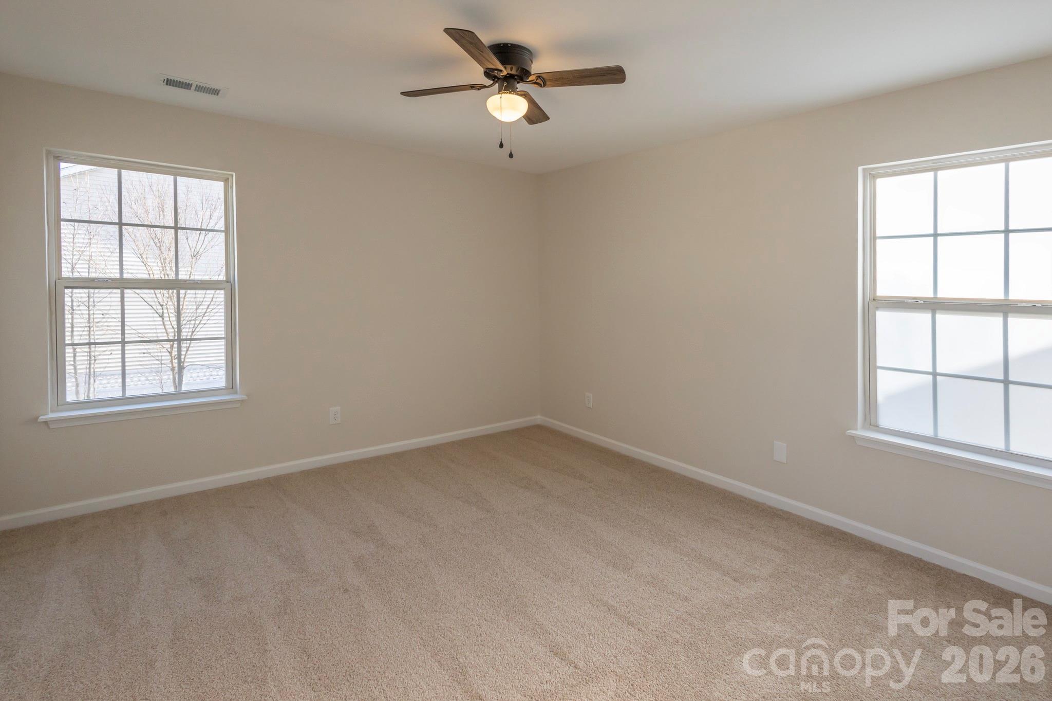 10631 Atkins Ridge Drive Charlotte, NC 28213 - Photo 28 of 38 an empty room with a window and a ceiling fan