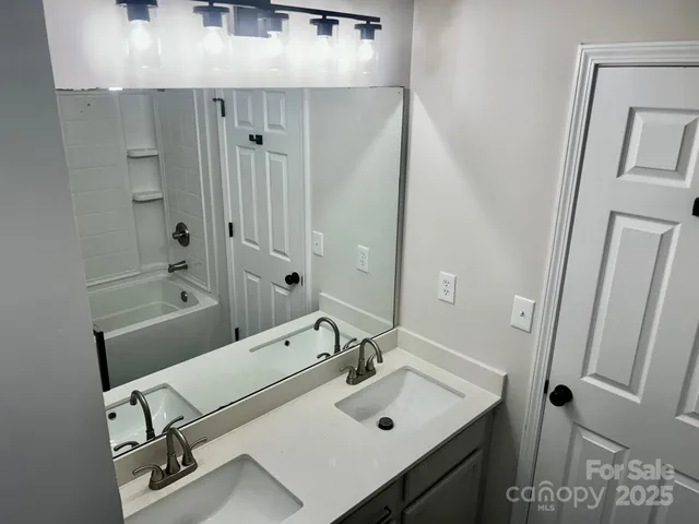 a bathroom with a sink a tub and a mirror