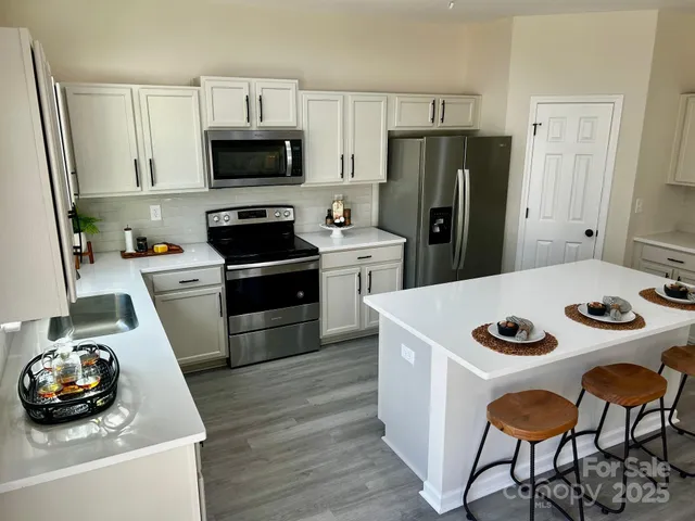 a kitchen with stainless steel appliances a stove a sink and a refrigerator