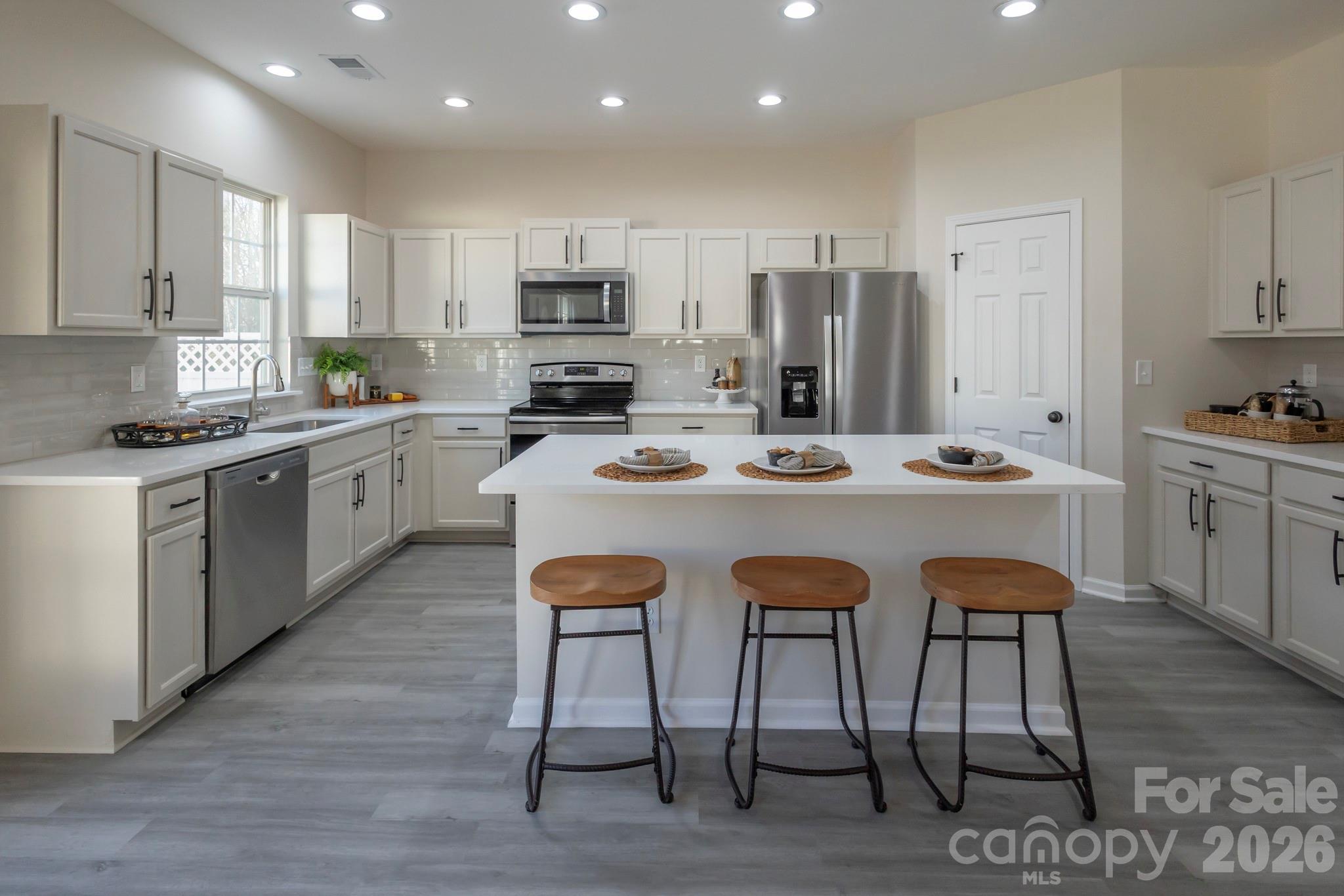 10631 Atkins Ridge Drive Charlotte, NC 28213 - Photo 4 of 38 a kitchen with stainless steel appliances granite countertop a table chairs sink refrigerator and cabinets