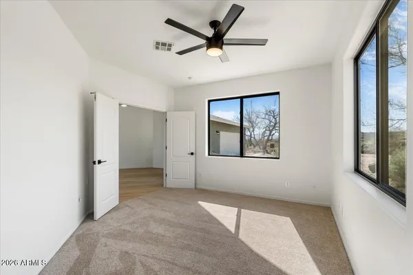 a view of a livingroom with a ceiling fan and window