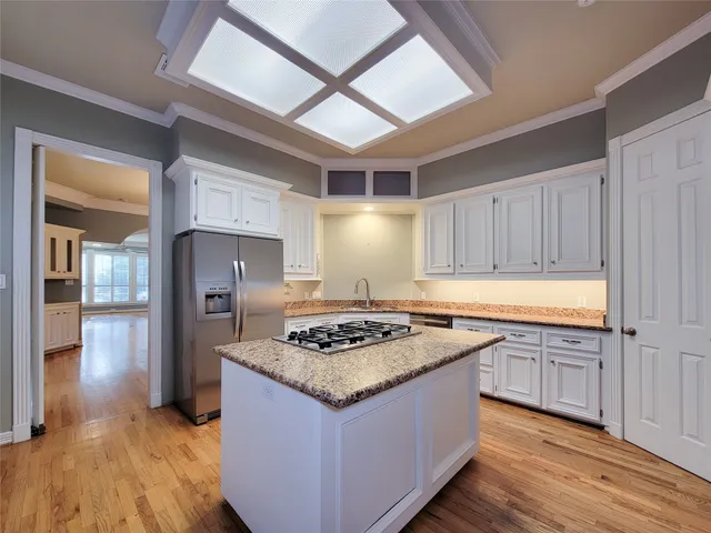 a kitchen with stainless steel appliances granite countertop wooden cabinets a stove a sink and a refrigerator