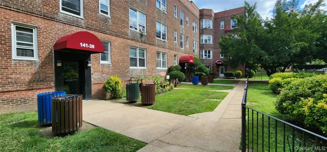 a view of a brick building with a yard and plants