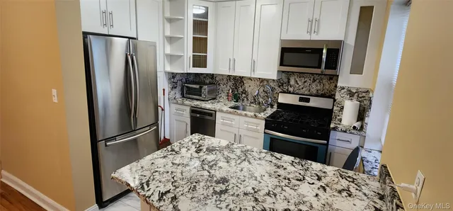 a kitchen with stainless steel appliances granite countertop a refrigerator stove and microwave