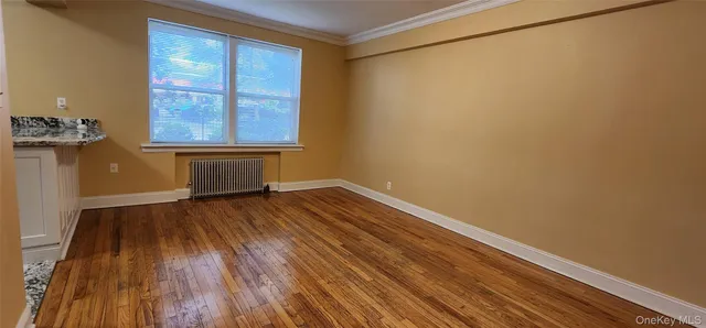 a view of room with window and wooden floor