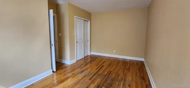 a view of a room with wooden floor and a window