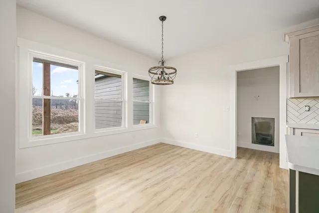 a view of a room with a window and wooden floor
