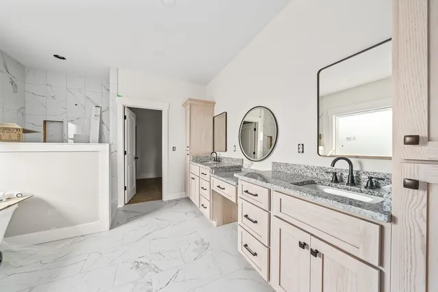 a spacious bathroom with a granite countertop sink mirror and a shower