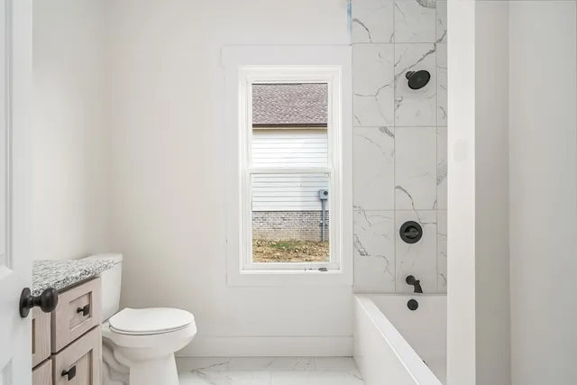a bathroom with a toilet and a shower