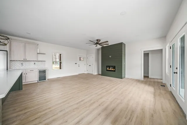 a view of a kitchen with wooden floor and a refrigerator