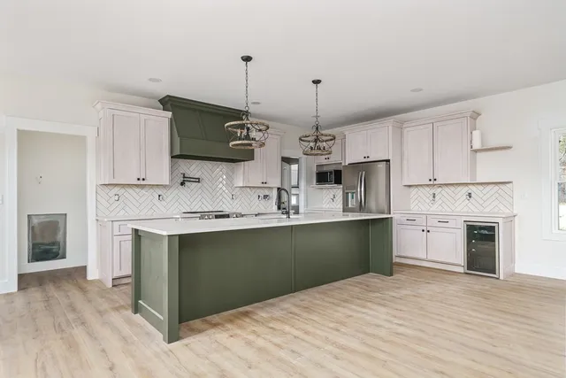 a kitchen with kitchen island a sink stainless steel appliances and cabinets