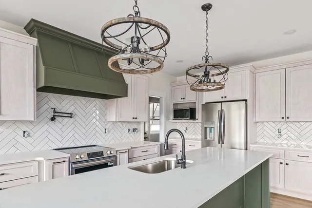 a kitchen with stainless steel appliances granite countertop a sink a stove and refrigerator