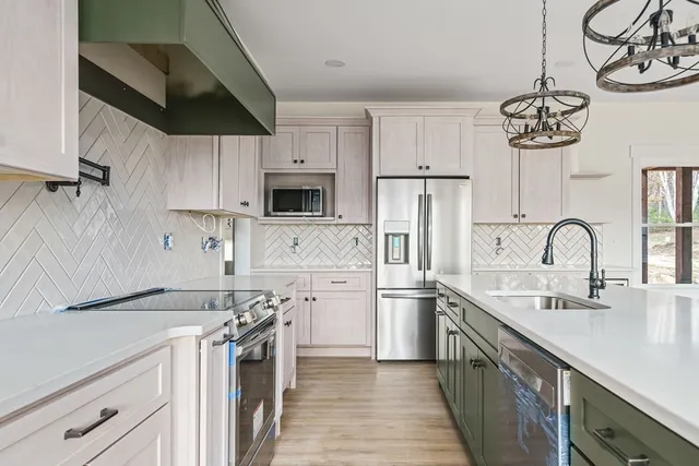 a kitchen with kitchen island white cabinets a sink a stove and oven