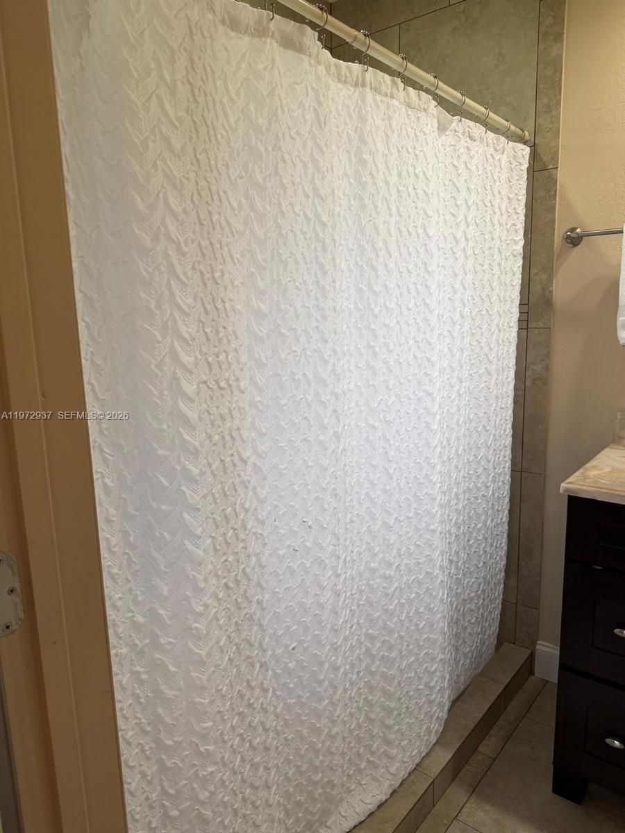 1350 Northwest 96th Street, Unit 2 Miami, FL 33147 - Photo 4 of 12 a bathroom with a shower curtain