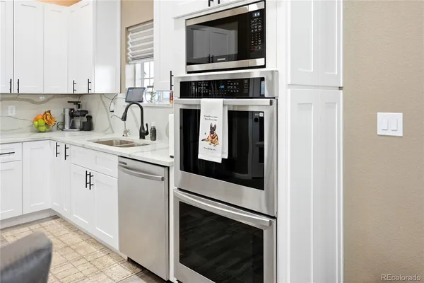 a kitchen with stainless steel appliances a stove microwave and sink
