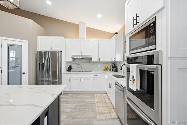 a kitchen with stainless steel appliances granite countertop a refrigerator stove microwave and sink