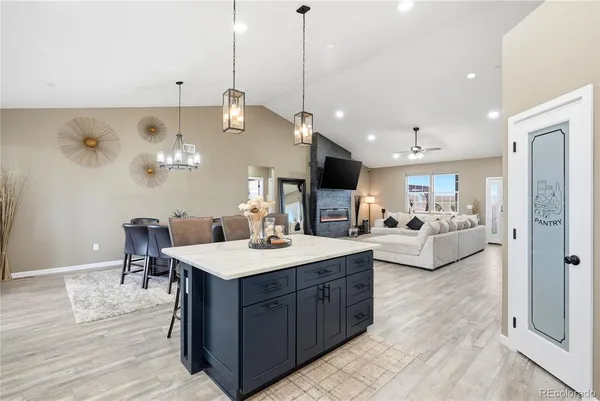 a kitchen with a stove a refrigerator a sink dishwasher with a dining table and chairs with wooden floor