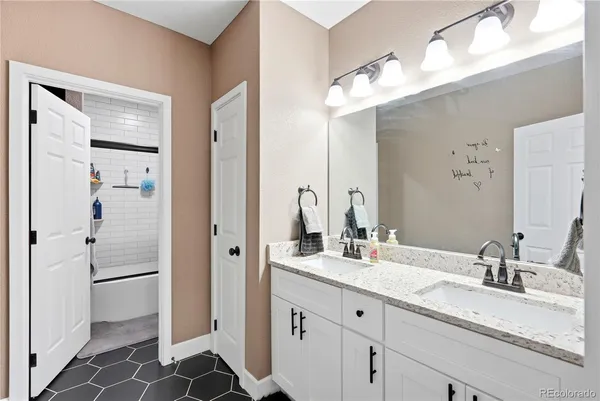a bathroom with a double vanity sink mirror and shower