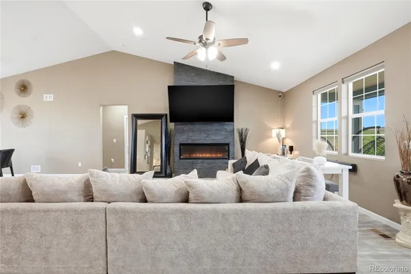 a living room with furniture a flat screen tv and a fireplace