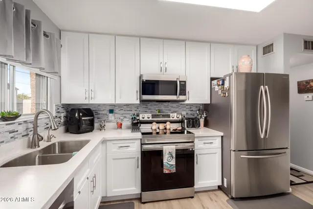 a kitchen with stainless steel appliances a refrigerator stove sink and cabinets