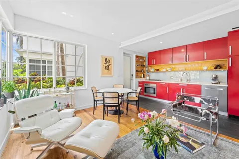 a living room with furniture a floor to ceiling window and wooden floor