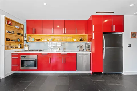 a kitchen with stainless steel appliances granite countertop a refrigerator and a stove